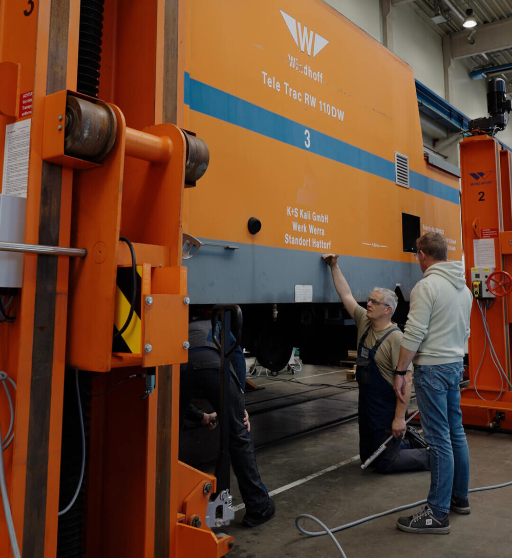 Drei Mitarbeiter bei der technischen Abstimmung zum Umbau des TeleTrac auf Elektroantrieb